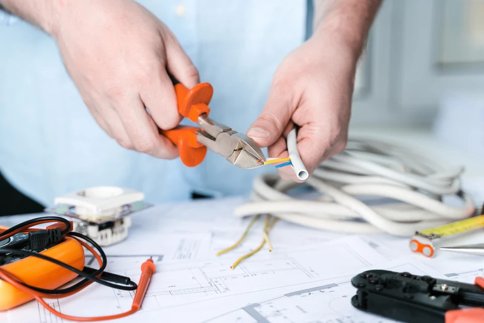 R&eacute;parateur d'homme r&eacute;alisant un projet d'&eacute;lectricit&eacute; &agrave; la maison