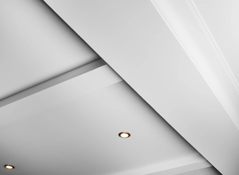 Plafond suspendu et à grilles avec lampes spots LED et construction de cloison sèche dans une pièce vide à l'intérieur de la maison