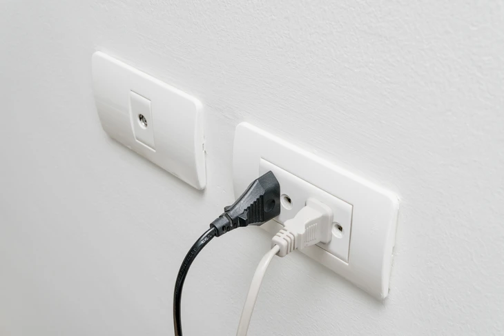 Scène intérieure sur fond blanc montrant un équipement électrique domestique en fonctionnement